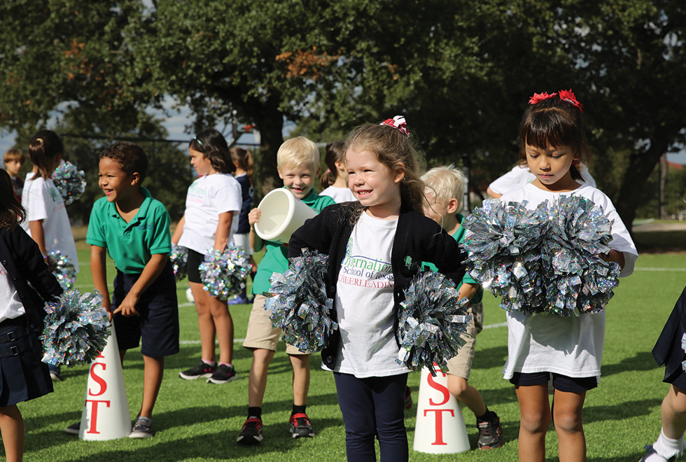 Cheerleaders celebrating the opening of their new Kickabout field from Hellas Construction.