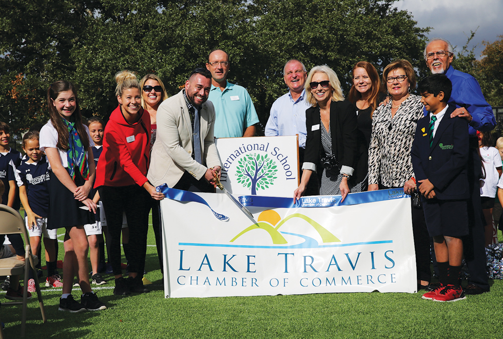 Tim Reilly with staff, students, and community members cutting the ribbon at the International School of Texas’ celebration of their new Kickabout field built by Hellas Construction.