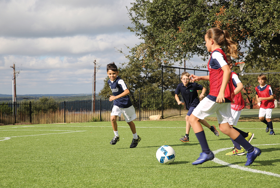 The IST soccer team playing a exhibition game on their new Kickabout field.