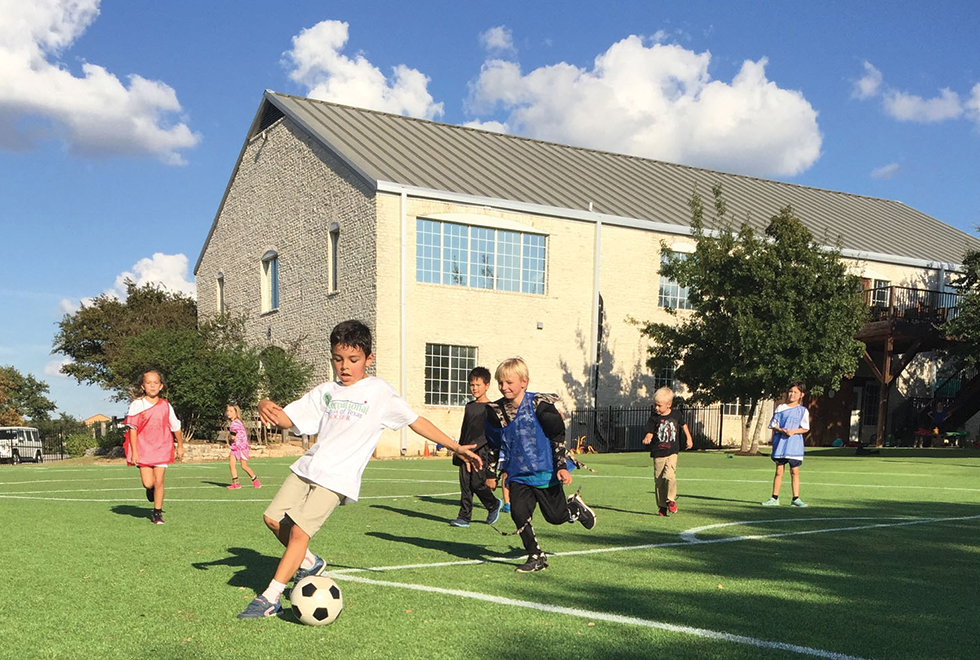 Kids at the International School of Texas playing soccer on their new Kickabout field.